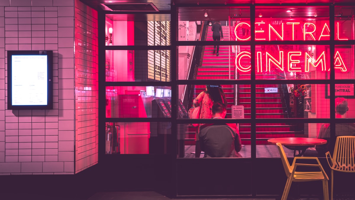 Fachada de cinema com letreiro de neon, representando o streaming de doramas