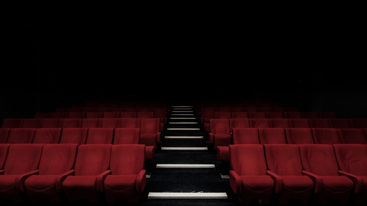 Poltronas vermelhas em uma sala de cinema escura